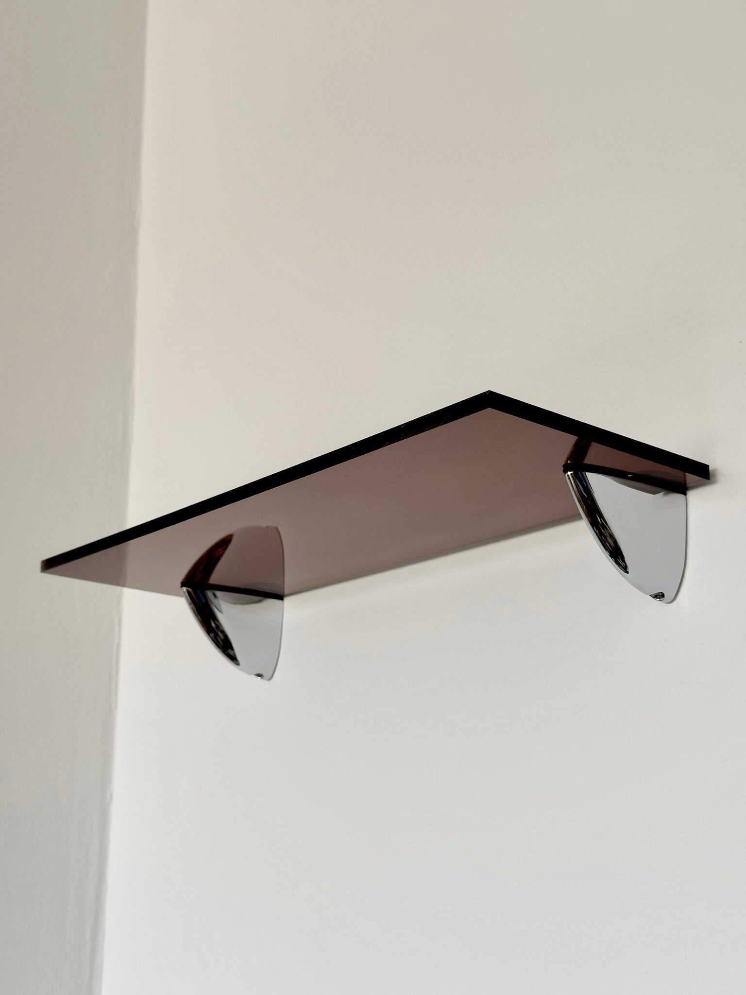 Wall shelf in Acrylic glass and chrome, tinted in smoky brown color shade, from French design studio 70space, inspired by the 70s interior design, gives a retro charm, solid materials in plexiglass / PMMA